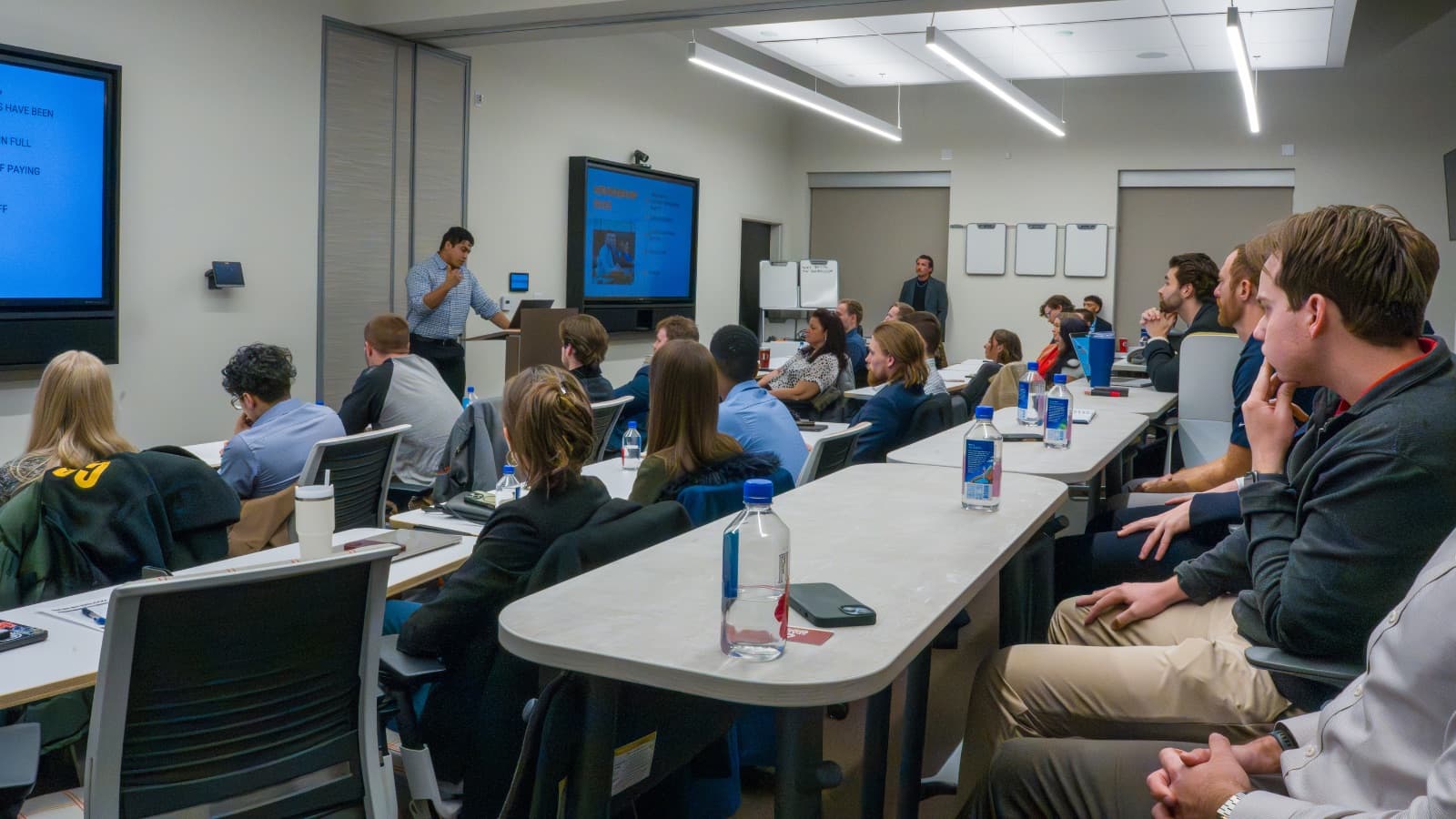 Professionals from different industries passing referrals at a referral networking group meeting